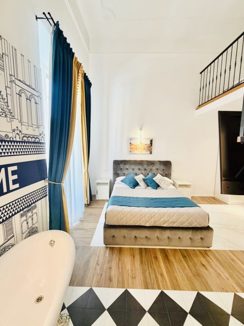 Elegante Suite Familiare al St Mary Major Loft Roma con letto queen, accenti blu, pavimenti in legno e vista sulla città