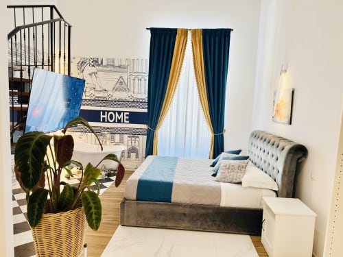 Camera Familiare Superior presso St Mary Major Loft Roma con vista sulla città, elegante letto, tende blu e oro, pianta in vaso e design moderno