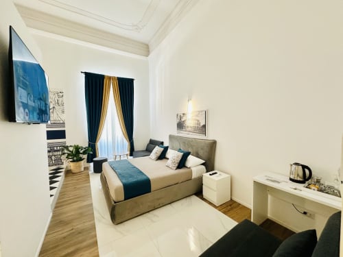 Deluxe Quadruple Room al St Mary Major Loft di Roma con vista sulla città, letto, TV e arredamento elegante