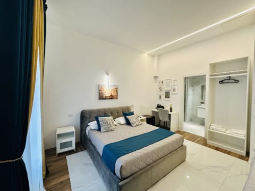 Camera da letto moderna in St Mary Major Loft a Roma con letto matrimoniale, accenti blu, bagno privato e vista sul giardino
