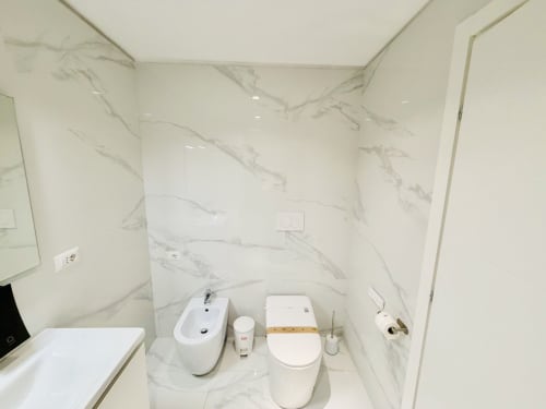 Bagno moderno del St Mary Major Loft Roma con pareti in marmo, bidet, wc e lavabo