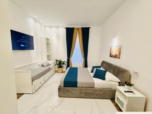 Camera tripla moderna presso St Mary Major Loft Roma con letto matrimoniale, divano-letto singolo, accenti blu e vista giardino