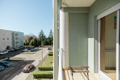 Varanda moderna do apartamento EcoHost Gaia com vista para estacionamento, edifícios residenciais e paisagismo em Portugal