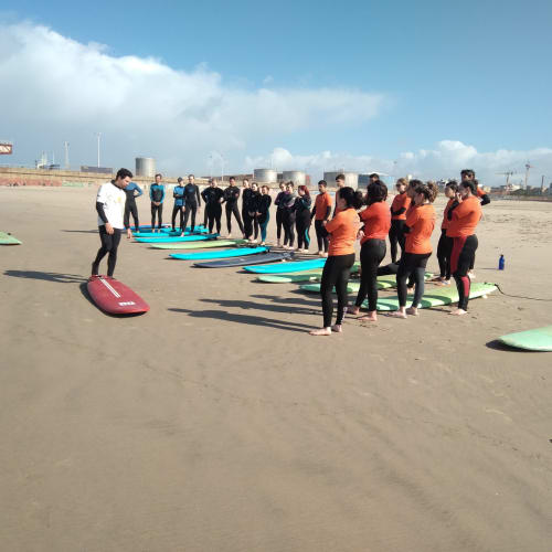 Aula de surfe em grupo na praia com pranchas coloridas na EcoHost Gaia Beach&Golf, Portugal