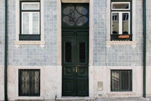 Fachada de apartamento em Lisboa com porta verde, paredes azulejadasе persianas de janela no 1898 Home & Suites