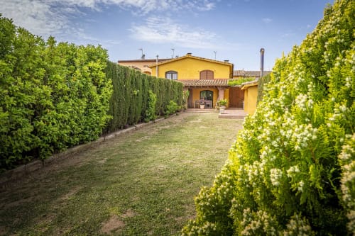 Finca rural de estilo toscano con villa amarilla, setos cuidados y amplios jardines en España