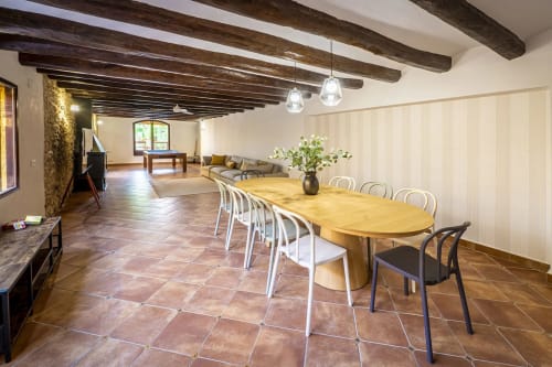 Amplio comedor rústico con vigas de madera, pisos de barro cocido y mesa ovalada en Estada Rural