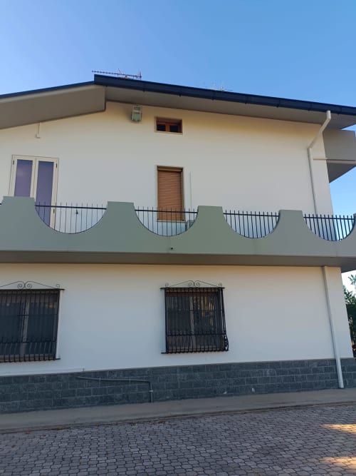 Edificio bianco a due piani con balcone presso Tales of Abruzzo, Atessa, caratterizzato da ringhiere in ferro battuto nero