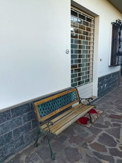 Wooden bench with teal cushion on patio at Tales of Abruzzo apartment in Atessa, Italy