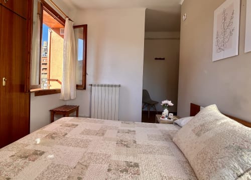 Cozy double room at Hostal Estació in Puigcerdà with wooden furnishings, radiator heating, and mountain views through the
