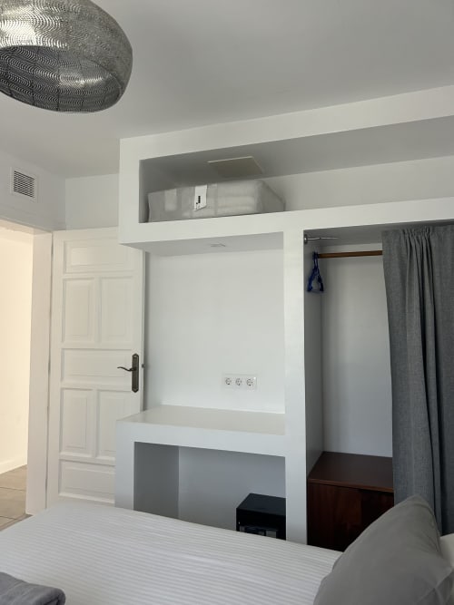 Habitación moderna con escritorio empotrado y armario en apartamento Kamalahouse SL, Corralejo, vista a la piscina