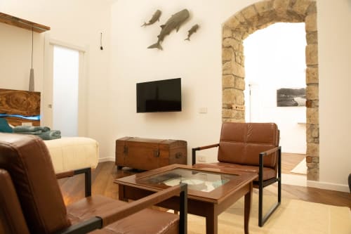 Nowoczesny salon w apartamencie S'Incantu w Sardegna Explora House, Magomadas, z skórzanymi siedzeniami i telewizorem plazmowym
