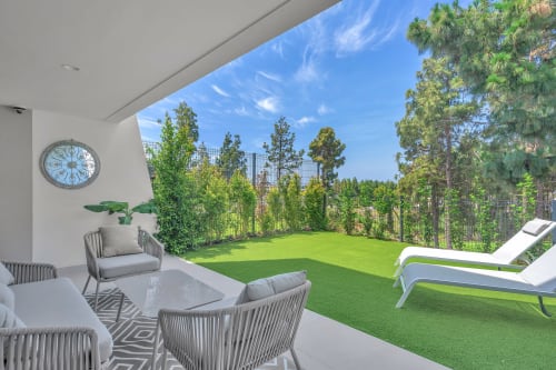HomyMarbella Elviria luxury patio with lounge chairs, artificial grass, and forest views