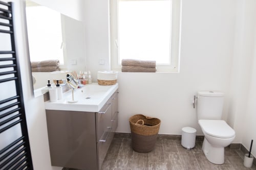 Salle de bains moderne de la Villa Rompsay à ARLOÉ, La Rochelle avec vasque, toilettes et lumière naturelle