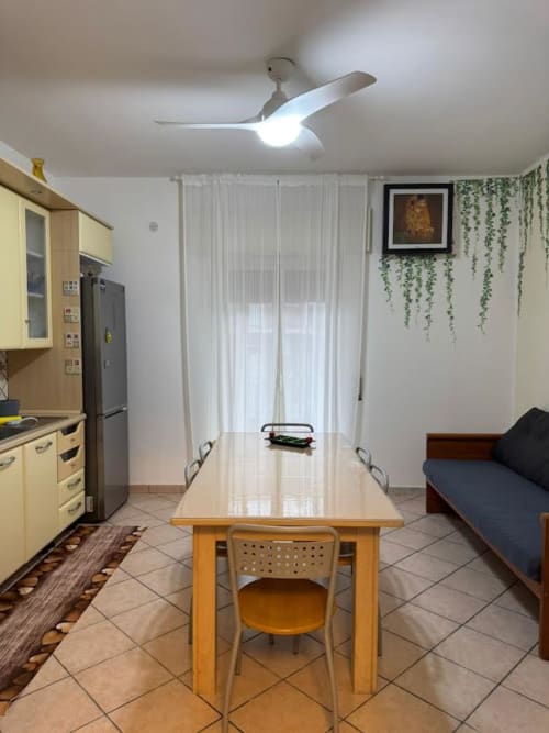 Cozinha e sala de jantar moderna em Catania com armários amarelos, mesa de madeira e ventilador de teto