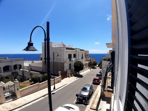 Vista della strada dell'appartamento Santa Cesarea Vacanze con balcone vista mare, lampione vintage e architettura mediterranea