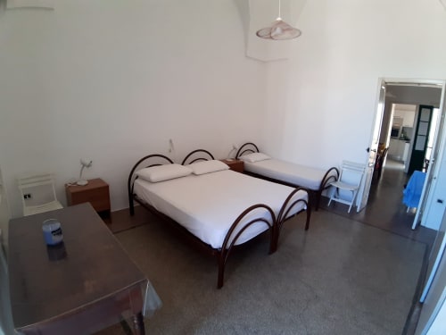 Spaziosa camera da letto a Santa Cesarea Vacanze con letti gemelli, mobili in legno scuro e vista giardino a Santa Cesarea Terme, Italia