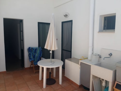 Appartamento Santa Cesarea Vacanze con terrazza esterna, zona pranzo, ombrellone bianco, angolo cottura e vista giardino
