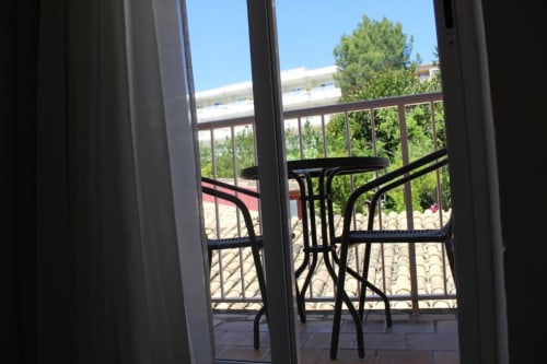 Vista de balcón desde habitación Deluxe en Villa Palmer en Paguera con vistas al jardín y edificio