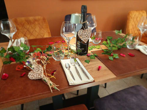 Table de salle à manger élégante au Clos De La Gourmandiere avec bouteille de vin, verres et composition florale