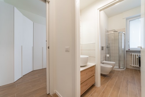 Bagno moderno nell'appartamento La Magnolia, Firenze - doccia, WC, lavabo con mobile in legno e pavimentazione in legno