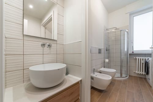 Bagno moderno nell'appartamento La Magnolia, Firenze con vasca rotonda bianca, doccia walk-in e pavimenti in legno