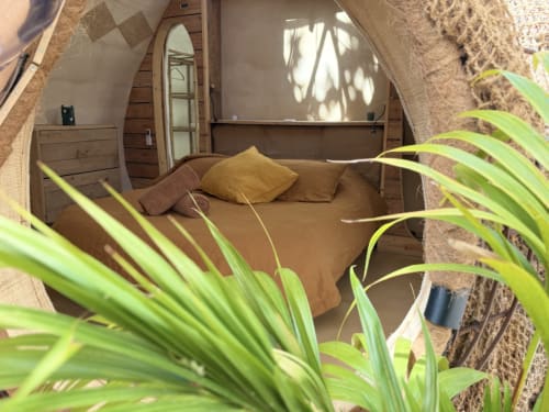 Cozy bedroom in Le Patio aux Oiseaux B&B, La Ciotat, with brown bedding and natural light through arched window