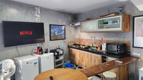 Cozinha da villa Philia em Florianópolis com área de refeições, fogão, geladeira e Netflix na TV