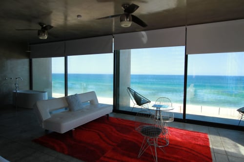 Suite moderna frente al mar en Vidasoul La Vinorama con vistas al océano, sofá blanco y alfombra roja
