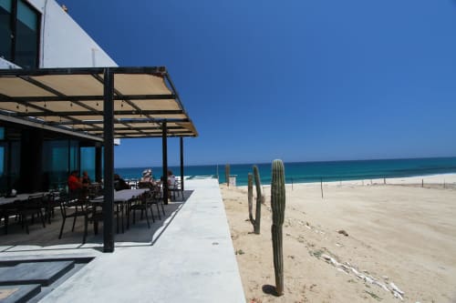 Patio frente al mar de Vidasoul con zona de asientos sombreada con vistas a la playa de arena y el océano en La Vinorama, México
