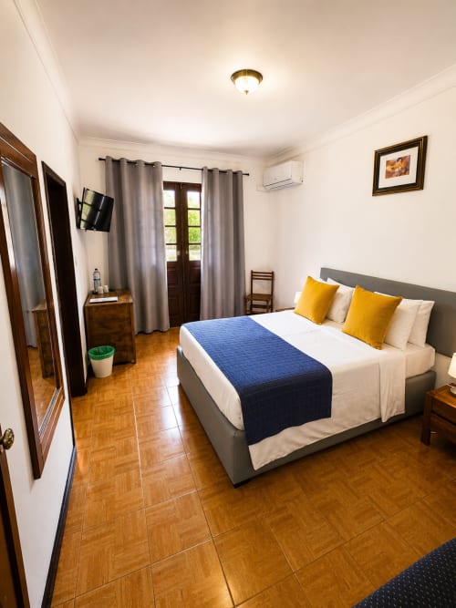 Espaçoso quarto com cama queen, vista para as montanhas, ar condicionado, TV e acesso à varanda na Serrana Gerês Inn