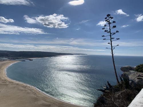 Vista abrangente da praia de Nazaré e do oceano do terraço do apartamento Casa na Onda à beira do penhasco