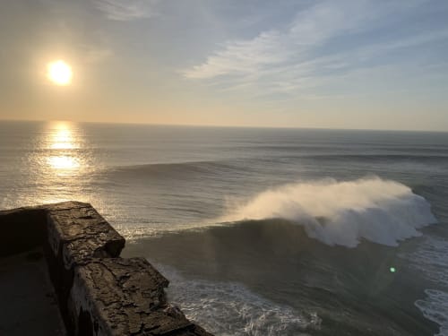 Vagues océaniques spectaculaires au lever du soleil depuis le belvédère Casa na Onda à Nazaré, Portugal