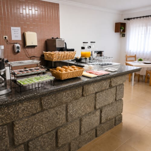 Serrana Gerês Inn: buffet de pequeno-almoço com pastelaria, pães, sumos e serviço de café na sala de refeições do hotel de montanha