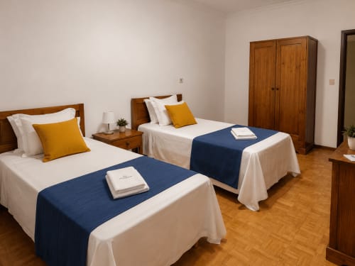 Quarto familiar na Serrana Gerês Inn com duas camas, móveis em madeira, vistas de montanha e decoração aconchegante em Gerês, Portugal