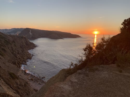Sunset over Nazaré bay with dramatic cliffs and calm waters from Casa na Onda apartment view