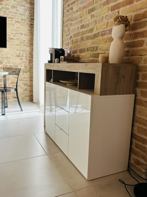 Modern suite kitchenette at NOUA LIVING Ravenna with exposed brick walls, minimalist storage and wooden accents