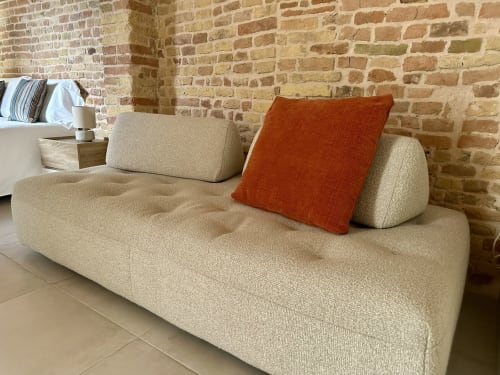 Beige modern sofa with orange pillow in Suite 3 apartment at NOUA LIVING boutique hotel in Ravenna, Italy