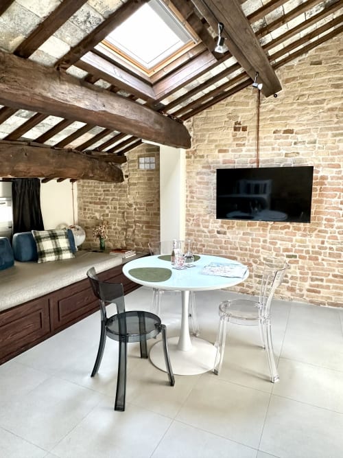 Moderno loft a Ravenna con muri in laterizio a vista, lucernario, zona pranzo e TV schermo piatto