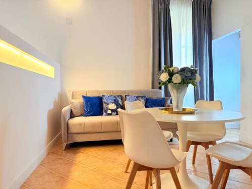 Elegante soggiorno moderno in Casa Cavour, CASA LOUNGE ISTRIA Cagliari con divano beige, tavolo da pranzo e vista sulla città