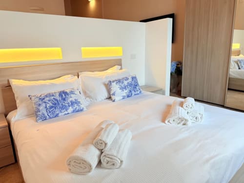 Camera da letto moderna dell'appartamento CASA CAVOUR presso CASA LOUNGE ISTRIA, Cagliari con letto matrimoniale, cuscini blu decorati e arrotolati