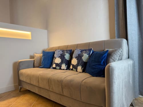 Elegante divano beige con cuscini blu e fantasia nell'appartamento Casa Cavour presso CASA LOUNGE ISTRIA, Cagliari