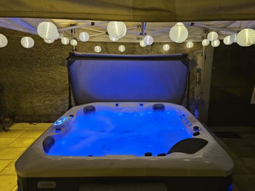 Illuminated hot tub with blue water under paper lanterns at Château de Ribourdin, Chevannes