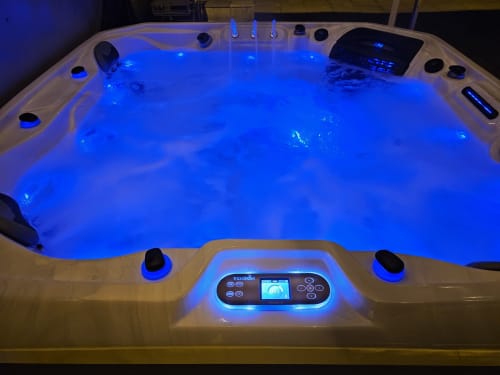 Illuminated hot tub with blue LED lights and control panel at Château de Ribourdin, Chevannes