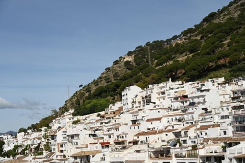 White hillside apartments in Elviria, Marbella with Mediterranean vegetation and mountain backdrop