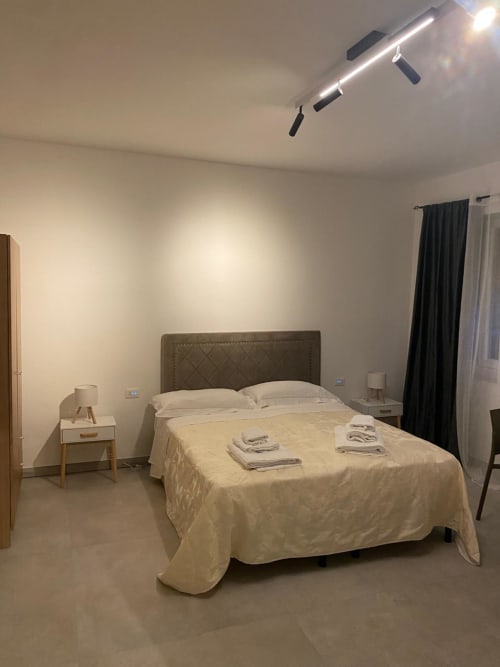 Modern bedroom at RL GROUP hotel in Civitanova del Sannio with queen bed, nightstands, and track lighting