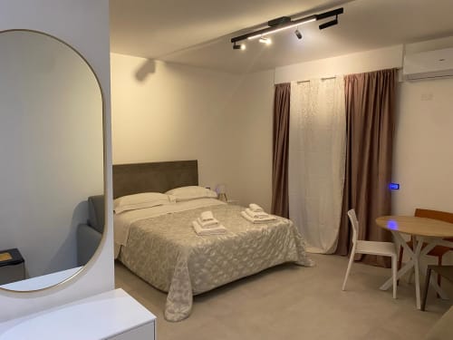 Modern bedroom at RL GROUP bnb in Civitanova del Sannio, Italy with queen bed, mirror, dining table