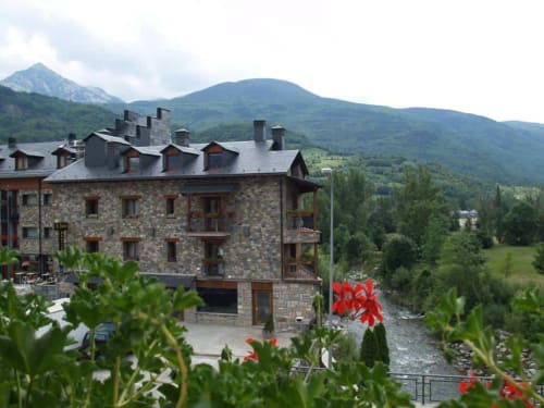 Edificio de piedra Hotel Llibrada con vistas a las montañas en Benasque, España