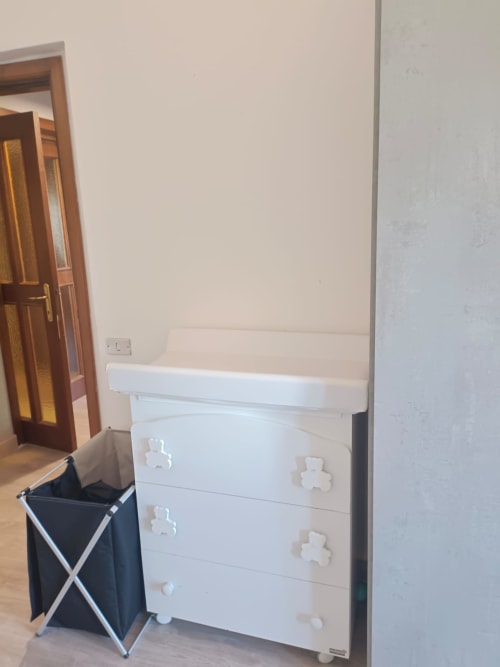 White dresser with storage drawers and changing table in apartment bedroom at Tales of Abruzzo, Atessa