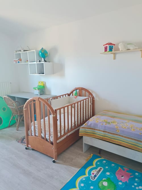 Bright nursery room with two wooden cribs, desk, and colorful toys at Tales of Abruzzo apartment in Atessa
